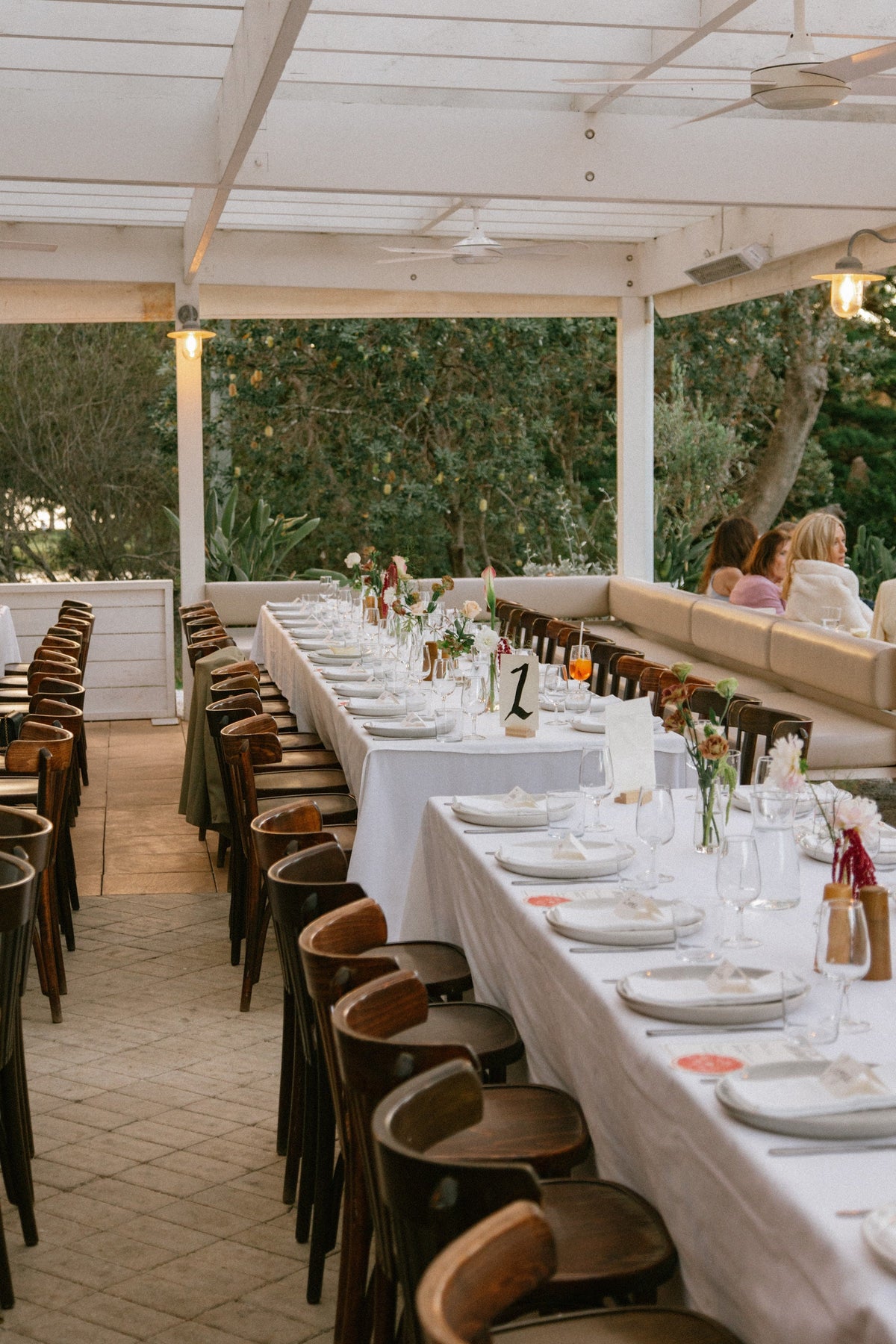 Long tables under the white pergola at Dunes Palm Beach set for a wedding