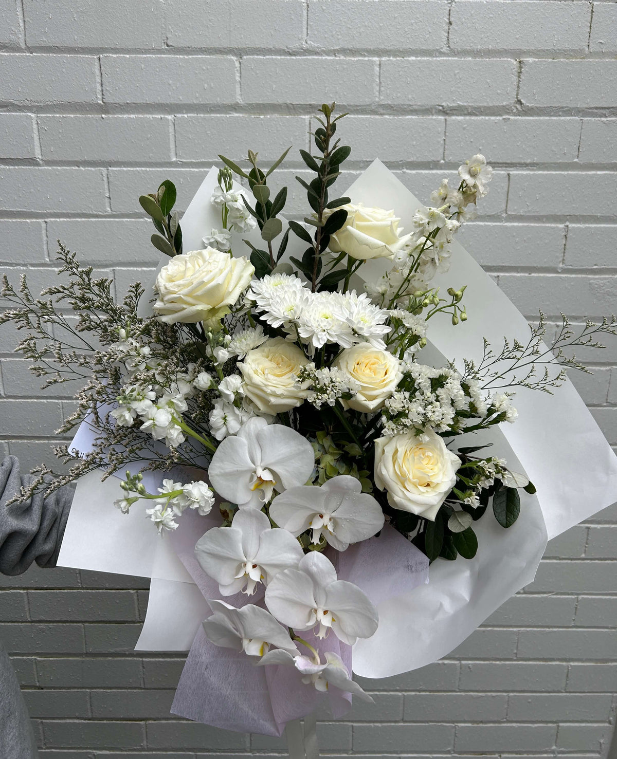 white flowers roses chrysanthemum orchids wrapped in white paper