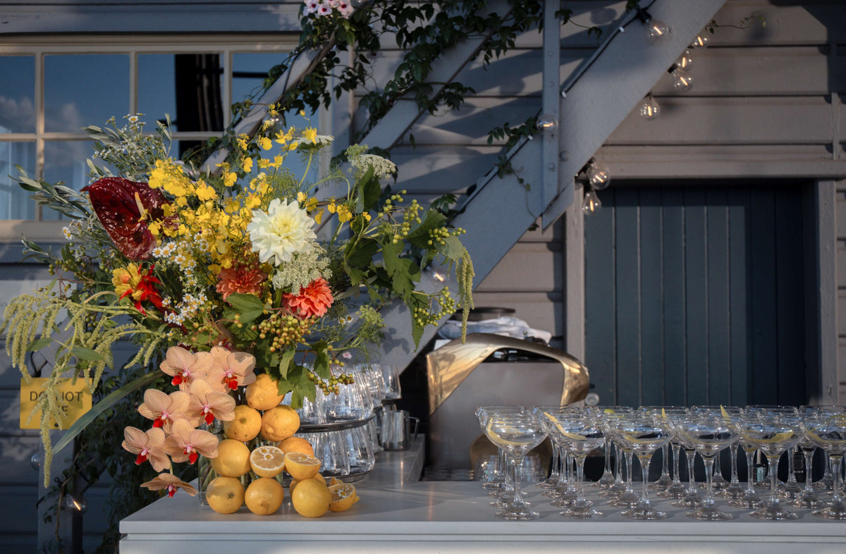 Decorative bar table setup with flowers, citrus fruits orchids for corporate event christmas party in sydney