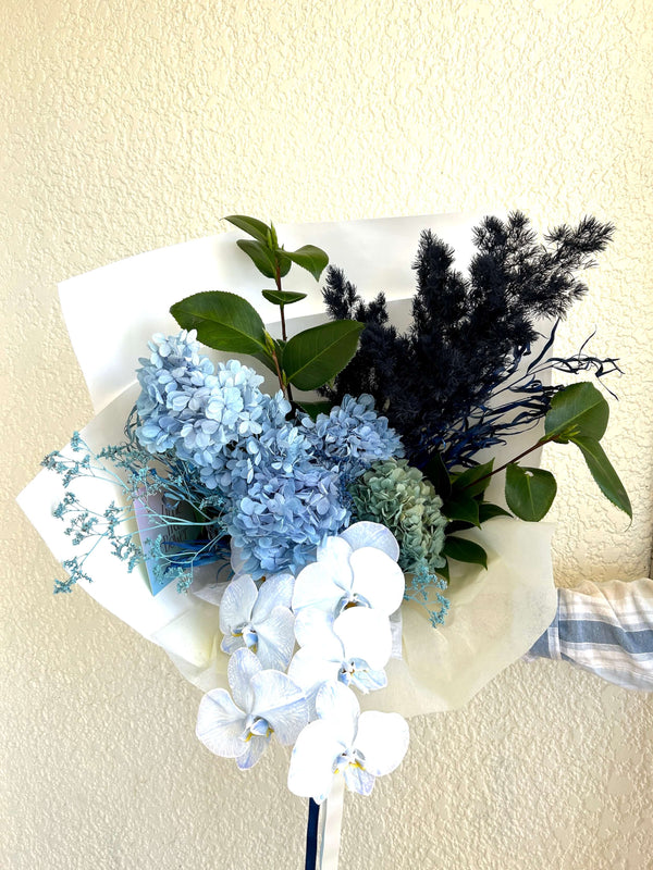 Bouquet of blue and white flowers with greenery on a light background for office client delivery