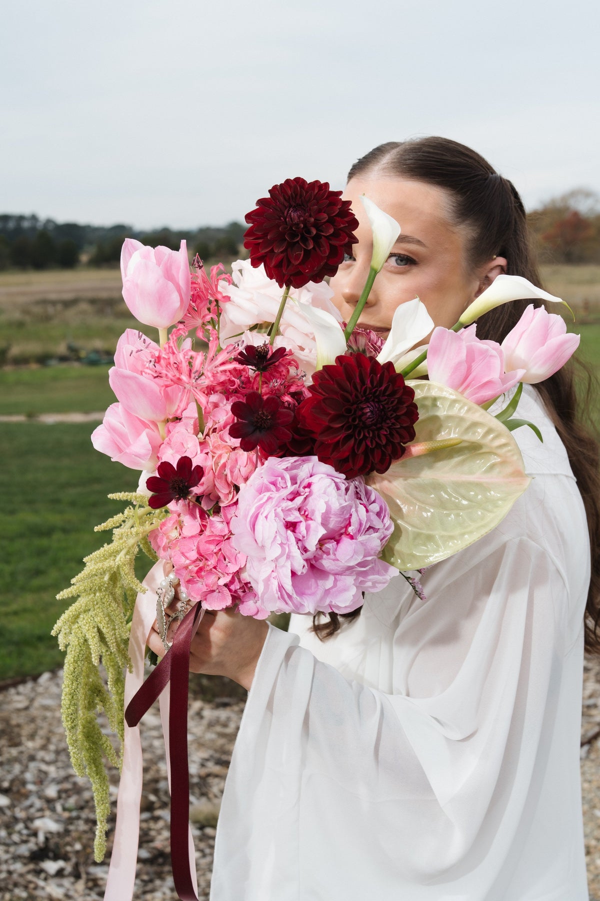 Amy's bridal bouquet in burgundy and pink with trailing ribbon, Bendooley Estate wedding
