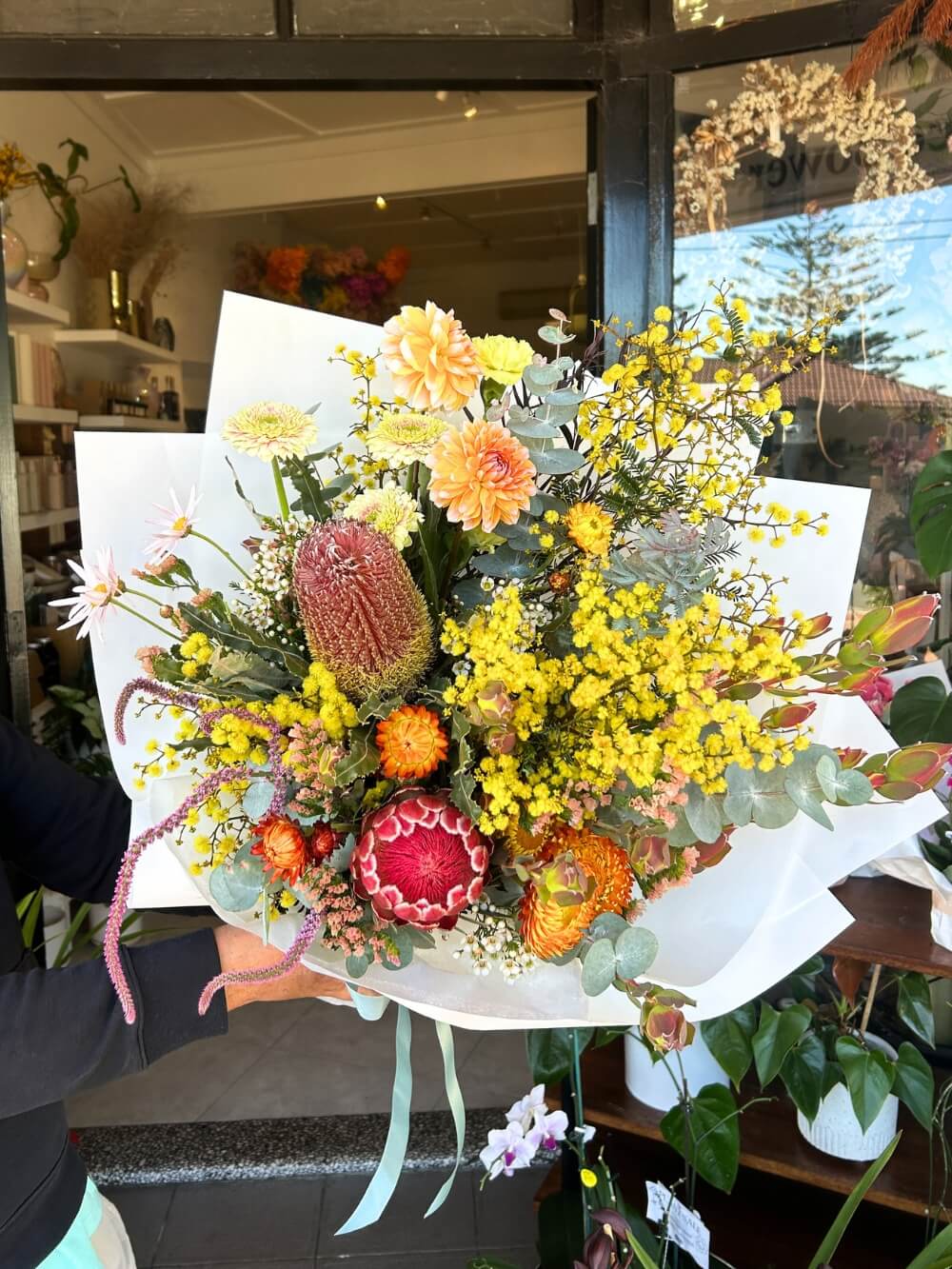 colourful yellow orange native flowers bouquet in front of sydney flower shop