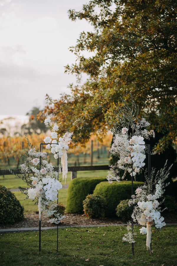 ceremony backdrop white flowers freestanding modern design at vineyard wedding