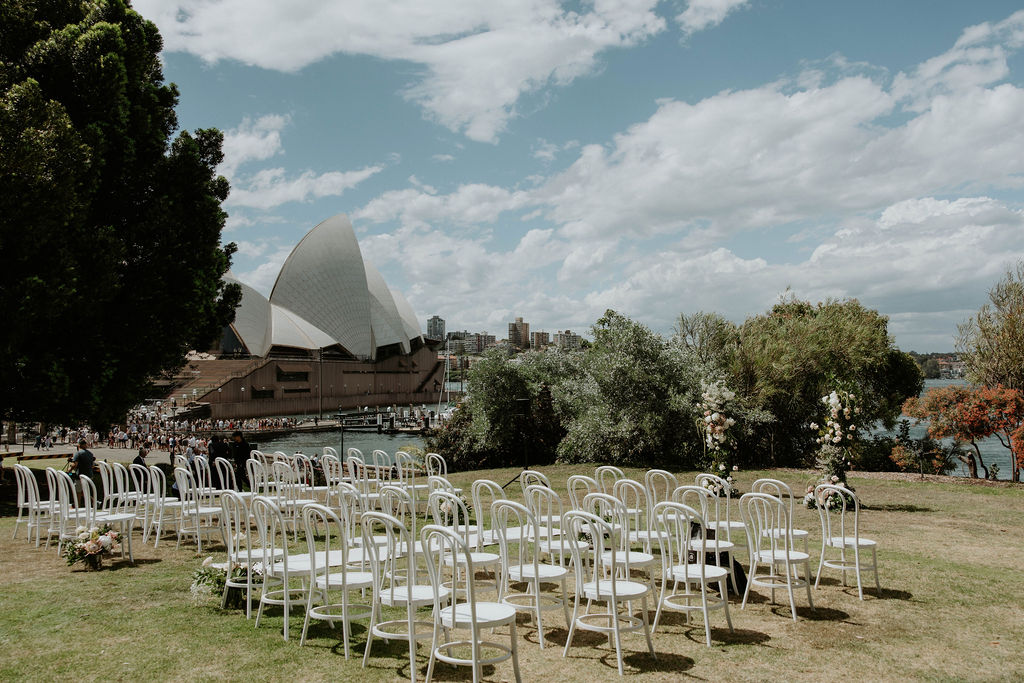 White chairs and floral arrangements set for a ceremony on the Australian Rockery Lawn